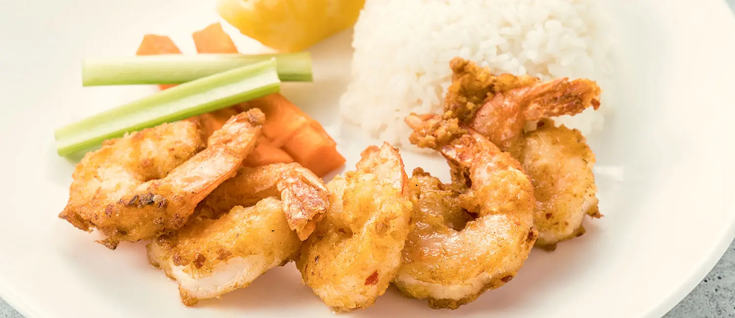 Fried shrimp plate served with rice and vegetables