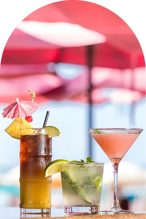 A woman enjoying a cheerful lunchtime under the beach umbrella at Mai Tai Bar