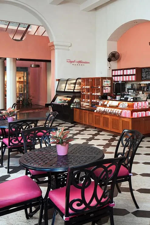 Inside the Royal Hawaiian Bakery—a stylish and calm café space with pink chairs and black iron-style tables