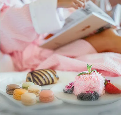 Photo of a woman relaxing on the bed with sweets