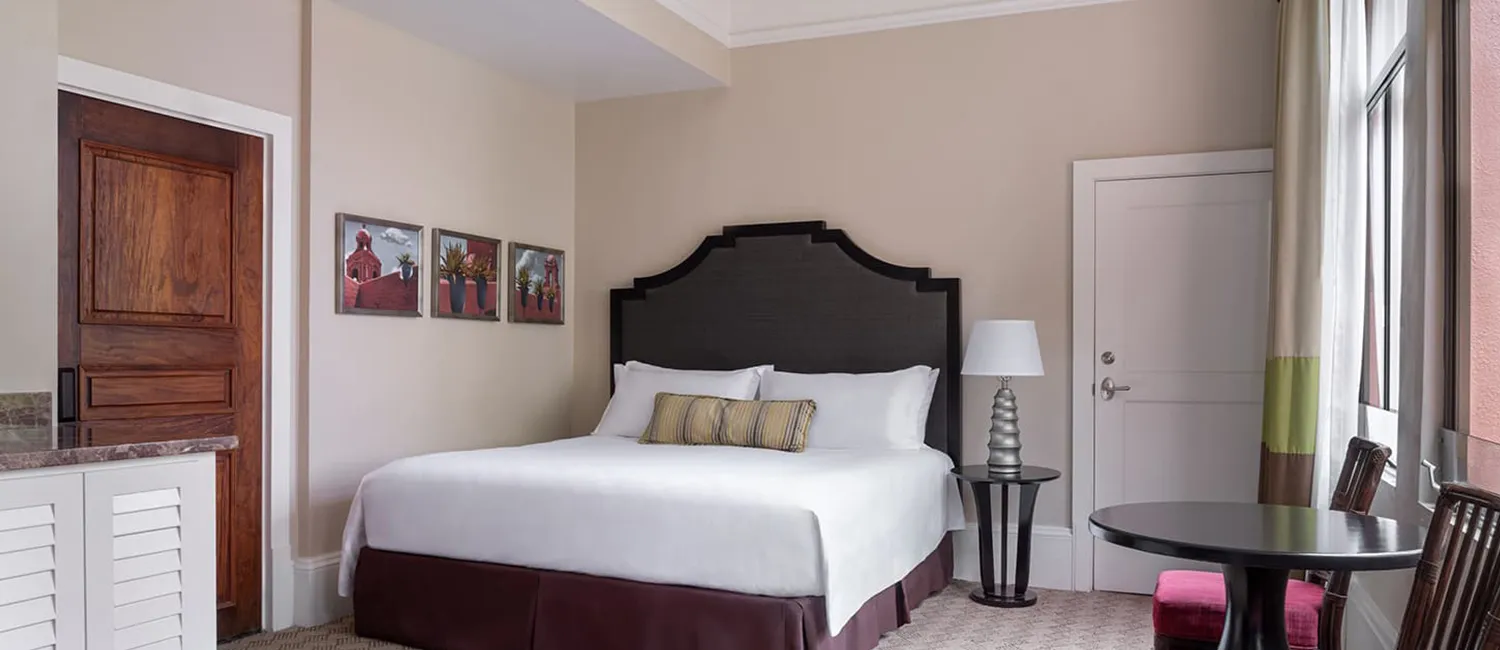 Bedroom of the Historic 3 Bed Family Room featuring a king bed and large windows in a calm, elegant setting.