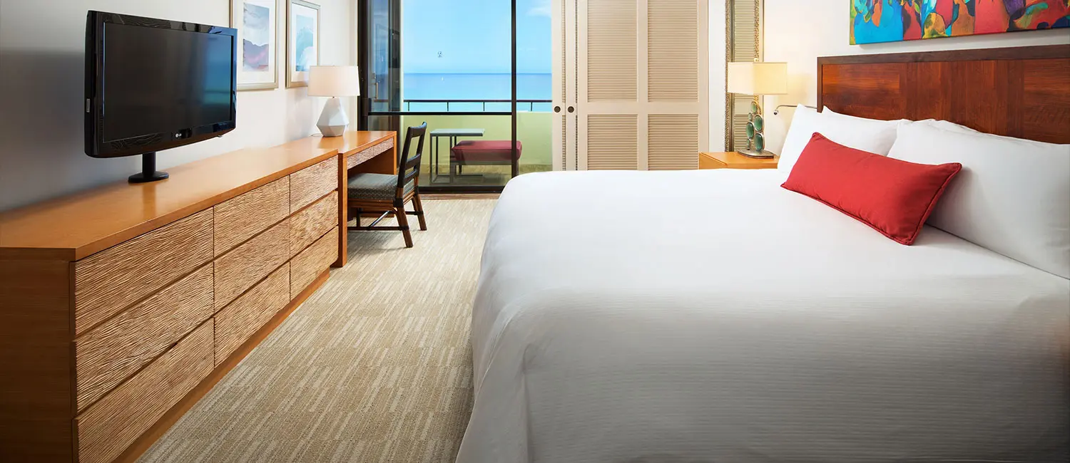 Bedroom featuring wooden furniture with a balcony view of Waikiki Beach.