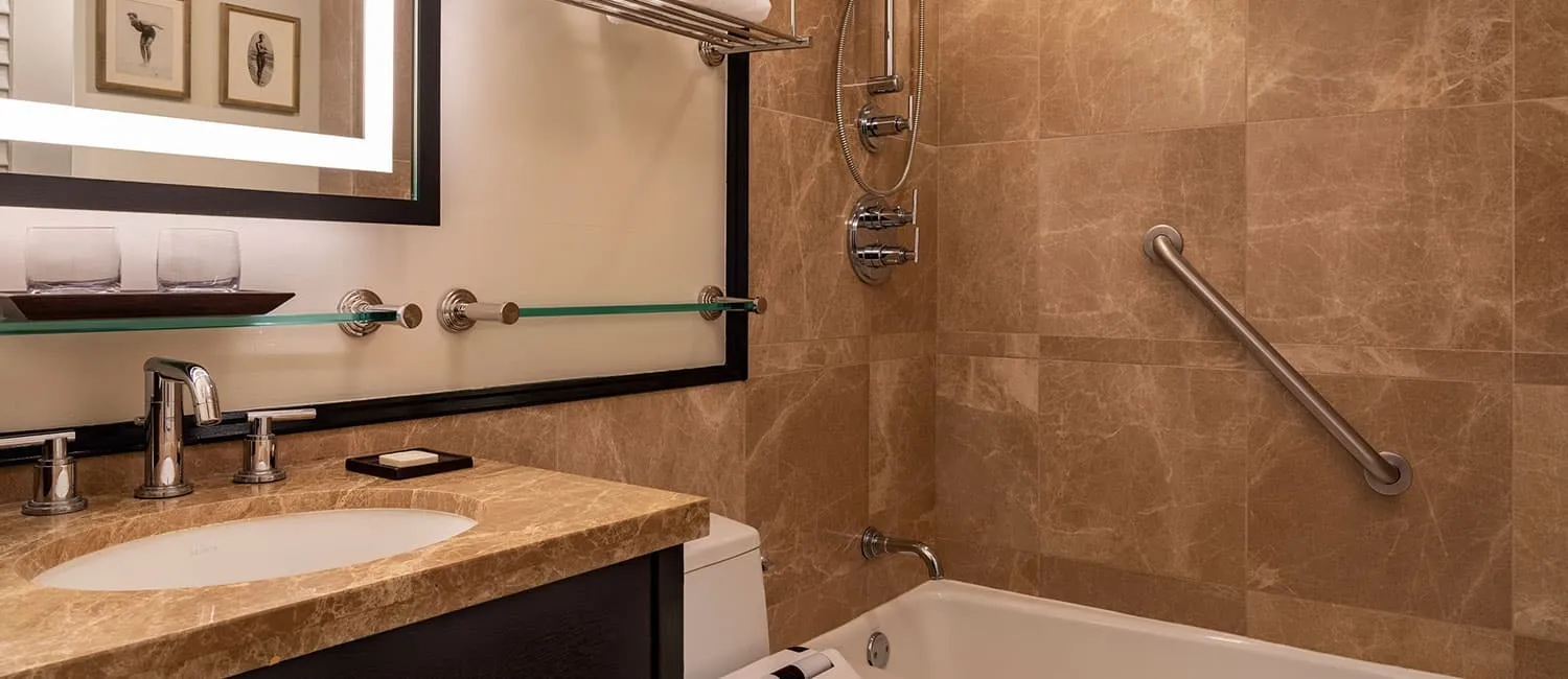 Elegant bathroom with a marble-style wall and bathtub.